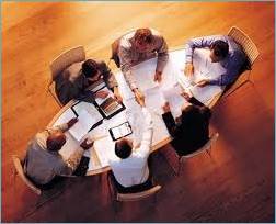 Six people sitting around an oval table 