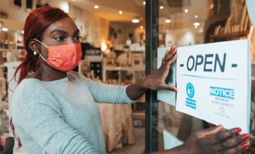 Masked teen putting sign on workplace door
