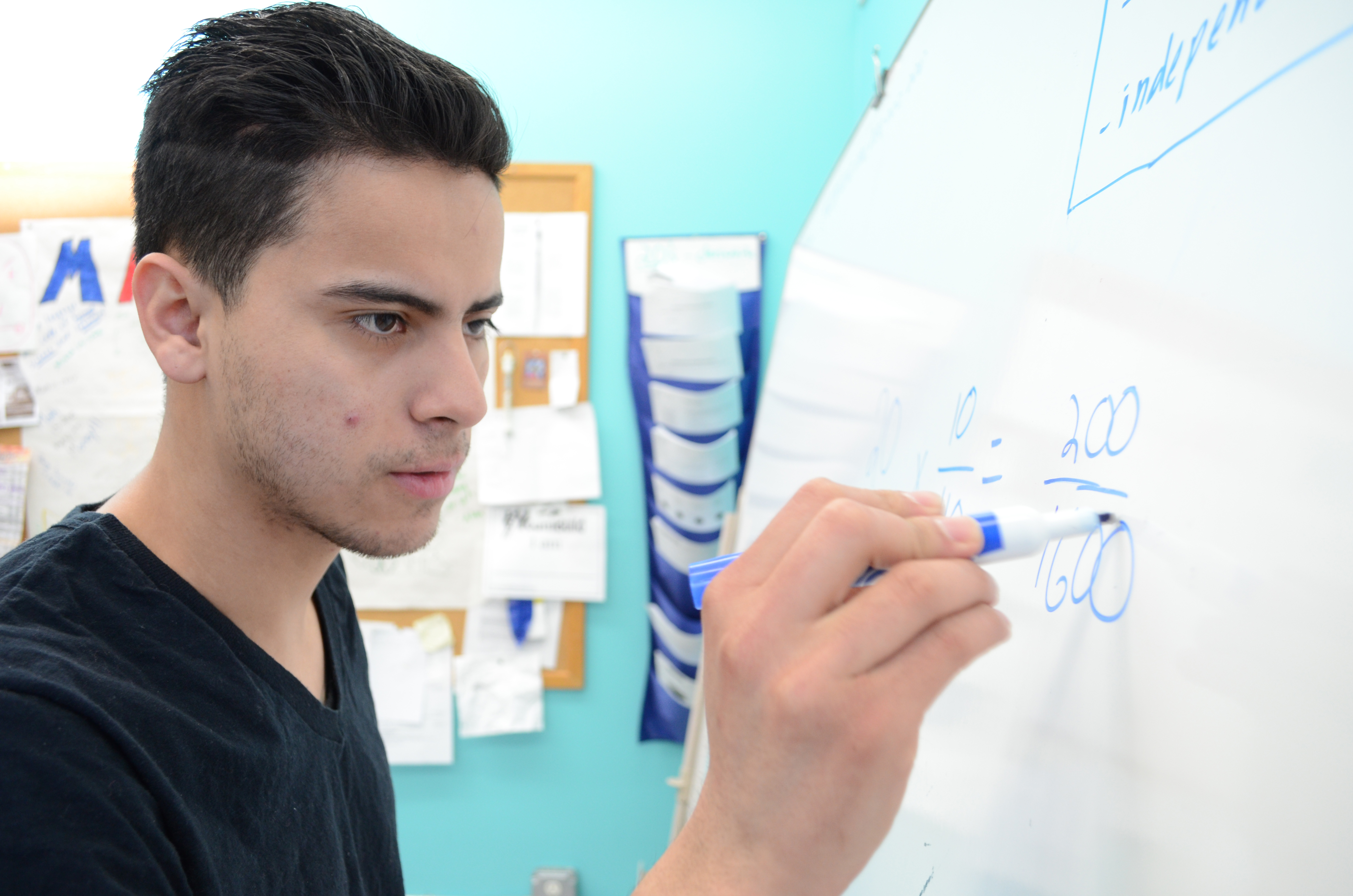 Student at whiteboard completing equation