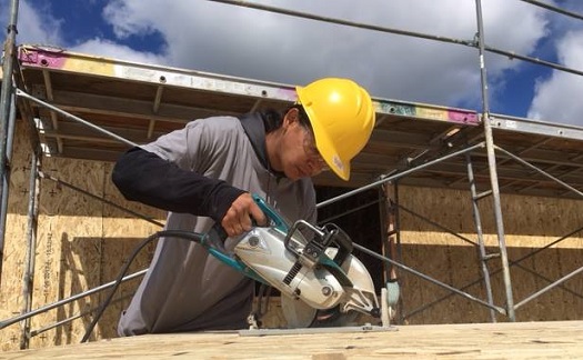 Man sawing wood on construction site