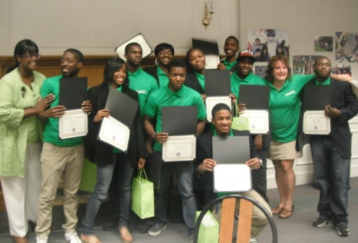 YouthBuild graduates holding diplomas