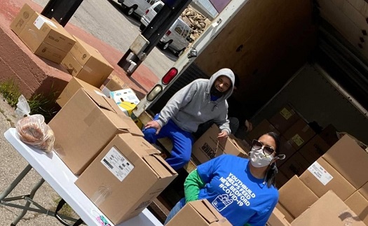 Two young people handling boxes of food at food bank