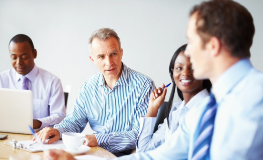 Four professionals at a conference table in discussion