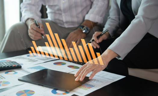 Two people in business attire reviewing data.