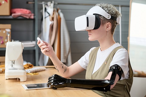 young female designer with partial arm in vr headset using remote control