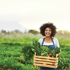Cropped portrait of an attractive young female farmer carrying a crate of fresh produce.