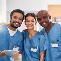Portrait of a group of cheerful young doctors standing together with a digital tablet inside of a hospital.