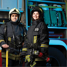 Image of happy fireman and woman near fire truck at station
