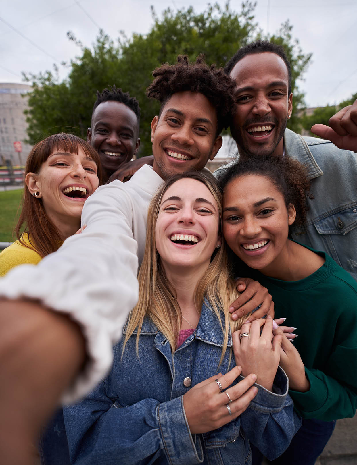 Vertical photo of Cheerful group of friends taking smiling selfie. Group of young people having fun together outdoors at park in the city enjoying travel in vacation holidays. High quality photo